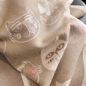 Détail d'une écharpe en maille douce avec motif chat et texture jacquard épaisse
