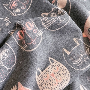 Détail d'une écharpe en tricot gris aspect cachemire avec motif jacquard de chat