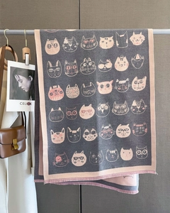 Détails d'écharpe tricotée avec motifs chats et franges roses sur tissu gris anthracite