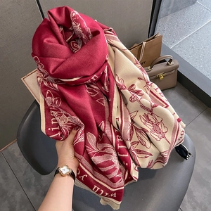 Thick winter scarf with red floral print and tassels, styled in a cozy casual setting