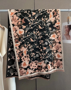 Détail du motif jacquard fleurs et oiseaux sur une écharpe d'hiver noire douce