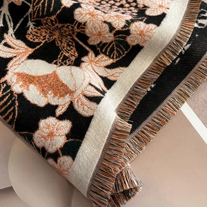 Détail du motif fleur et lapin avec franges colorées sur une écharpe en cachemire