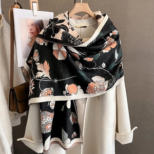 Détail d'une écharpe à fleurs vintage avec glands sur un manteau en laine