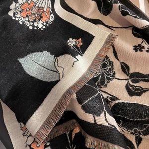 Gros plan sur la maille à motifs floraux et les franges colorées d'une écharpe d'hiver