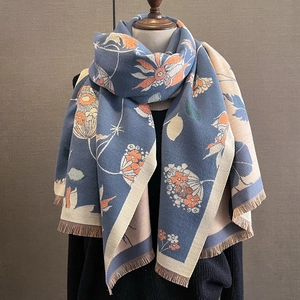 Détail de l'écharpe bleue motif floral style cachemire avec franges et texture tricotée épaisse