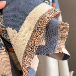 Gros plan d'une écharpe en cachemire jacquard avec texture épaisse et franges colorées