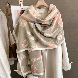 Détail d'une écharpe fleurie aspect cachemire avec motifs orange et bords à franges