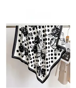 Détail d'un carré de soie satinée avec imprimé rose noire et motif à pois classiques
