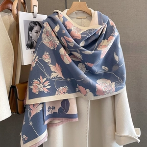 Détail d'un châle aspect cachemire bleu et rose avec imprimé floral et franges fines