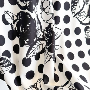Détail macro de pois et de roses noires imprimés sur un tissu léger de foulard en soie