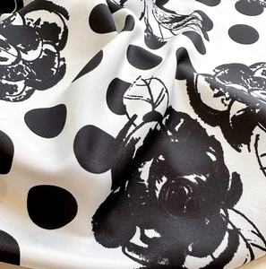 Vue macro du tissu en sergé présentant des motifs de camélias noirs et de pois