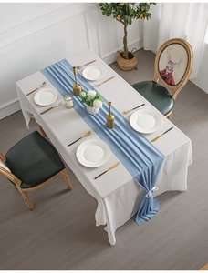 Close-up of light blue table runner with elegant ribbon ties on a white tablecloth