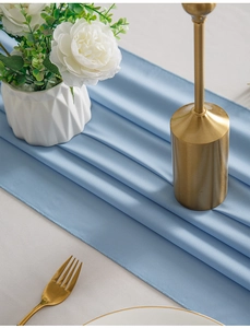 Close-up of light blue table runner with refined hemmed edges and matte texture
