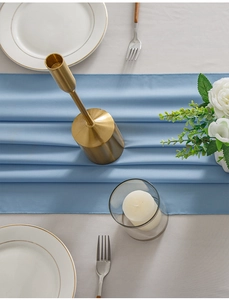 Detail of light blue minimalist table runner with smooth silk texture and elegant cutlery