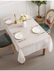Detail of jacquard tablecloth fabric featuring colorful mini pom poms and soft texture