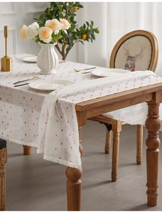 Close-up of white jacquard tablecloth with colorful dot pattern and matching runner