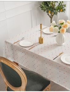 Detail of white tablecloth featuring colorful jacquard tassels and textured fabric