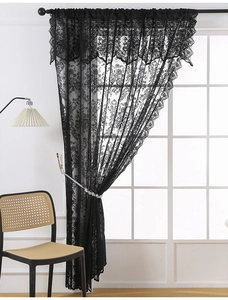 Detail of vintage French black lace curtain featuring delicate floral patterns and scalloped edges