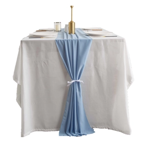 Elegant light blue chiffon table runner draped over white cloth for banquet decor