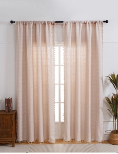 Detail of pink cotton linen bohemian curtains featuring white cross patterns and tassels