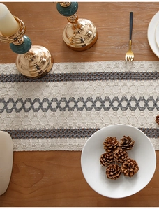 Detailed knit texture of a beige and gray striped table runner with geometric patterns