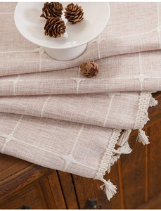 Detail of bohemian striped linen curtain with cross embroidery and decorative tassels