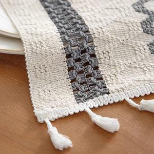 Striped cotton table runner with woven geometric texture and decorative white tassels