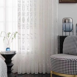 Detailed close-up of white sheer lace curtain with elegant damask floral embroidery