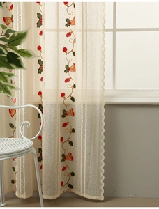 Detail of Christmas bell embroidery on beige sheer curtain with scalloped lace edge