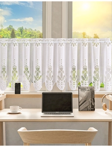 Detailed close-up of white lace kitchen cafe curtain with intricate floral patterns