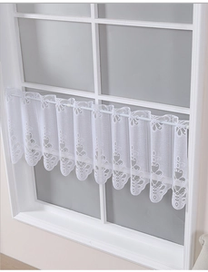 Close-up of white lace kitchen cafe curtain with floral patterns and scalloped edges