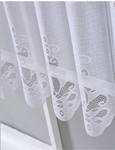 Close-up of white lace curtain featuring delicate floral embroidery and wavy scalloped edges