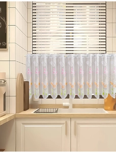 Close-up of white lace curtain featuring colorful butterfly embroidery and scalloped edges