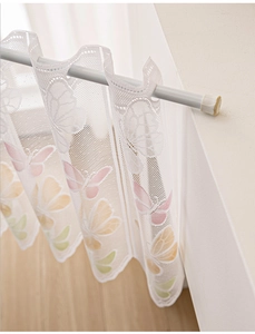 Detail of white lace cafe curtain with colorful butterfly patterns on a tension rod