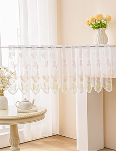 Detail of white lace cafe curtain featuring gradient butterfly prints and scalloped edges