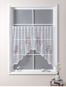 Detail of floral embroidery on white lace cafe curtain with scalloped wave edges