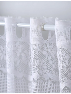 Close-up of white lace curtain showing delicate floral texture and rod pocket design
