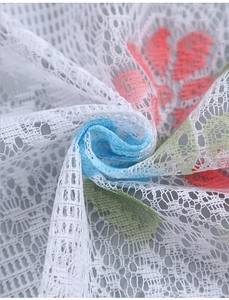 Detailed close-up of white lace fabric with colorful floral embroidery for curtains