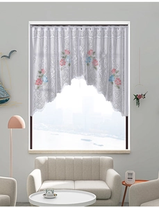 Detailed close-up of white lace curtain with red rose embroidery and wavy hem edge