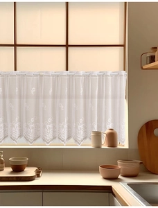 Detail of white daisy lace kitchen curtain with hollowed scalloped edges and floral embroidery