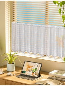 Detailed embroidery of daisies on white lace cafe curtain with delicate wavy lace edge