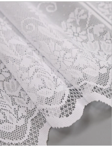 Detail of white daisy lace fabric with intricate hollow flower embroidery and scalloped edges