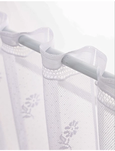 Detail of white daisy lace curtain showing sheer floral embroidery and rod pocket
