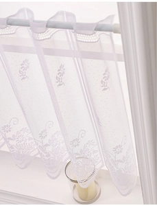 Detail of white lace cafe curtain with floral embroidery and rod pocket header