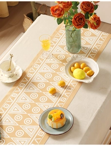 Dettaglio del runner da tavola giallo con motivi geometrici e decoro floreale
