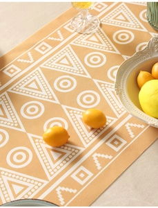 Dettaglio del runner da tavola geometrico giallo con tessuto impermeabile e margherite