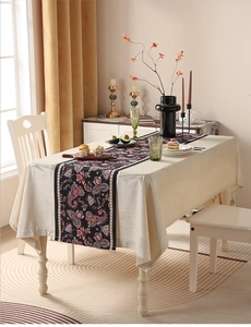 Dettaglio del runner da tavola boho con motivo paisley su tovaglia color crema