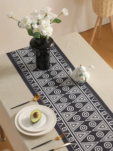 Detail view of Bohemian geometric table runner with tassels in a stylish home setting