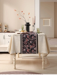 Dettaglio del runner vintage con uccelli e fiori su tovaglia crema e decori moderni