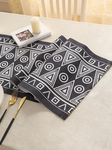 Close-up of bohemian geometric table runner with thick black and white printed fabric
